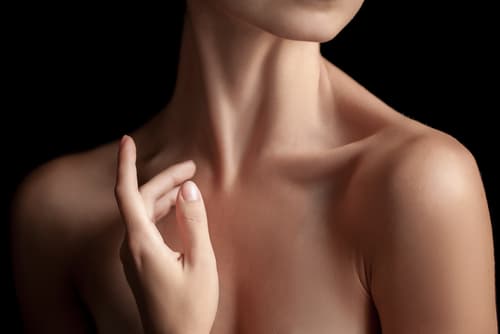 The close-up of a young womans neck and hands on dark background-img-blog