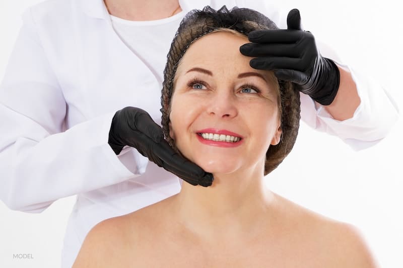 Women preparing to undergo a facial treatment with doctors hands surrounding face.