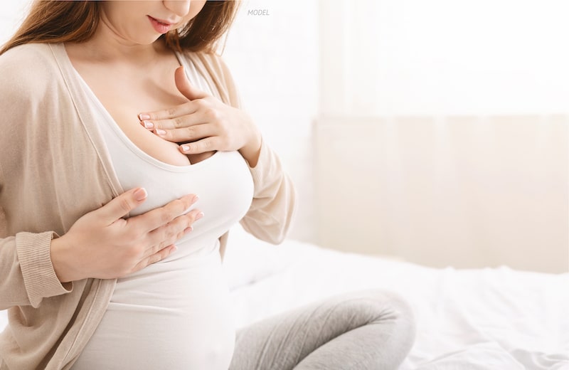 Pregnant women feeling her breast.