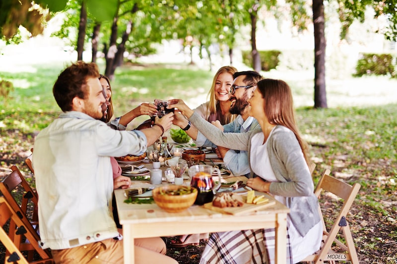 Group of friends toasting with their glasses at a table.